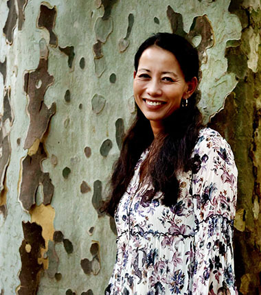 Lisa Hirschberg Lisa Hirschberg steht vor einem Baum und lächelt in die Kamera.